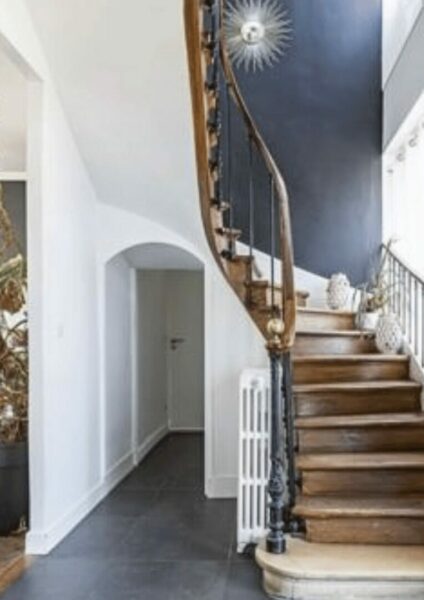 Escalier-en-bois-avec-mur-bleu-foncé-et-lumière-naturelle