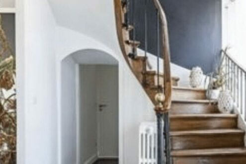 Escalier-en-bois-avec-mur-bleu-foncé-et-lumière-naturelle