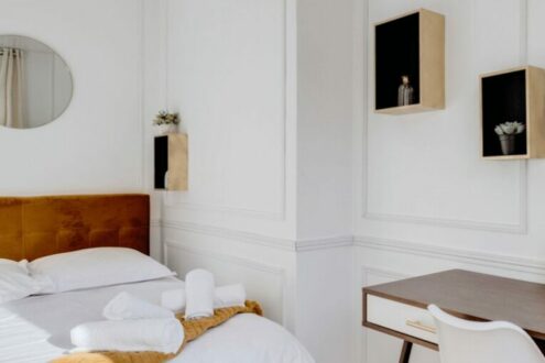 Chambre lumineuse avec lit double, bureau et accents dorés