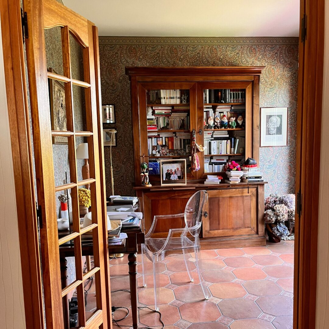 Chambre avec étagères en bois, fauteuil transparent, architecte intérieur Toulouse.