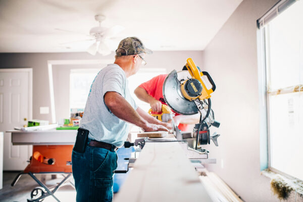 artisans en train de découper des planches pour rénover