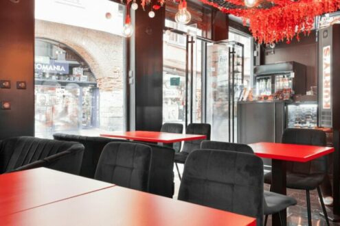 Intérieur de restaurant contemporain avec tables rouges et décorations au plafond