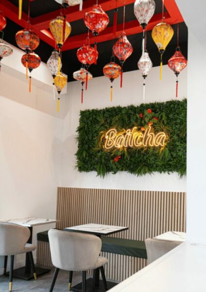 Intérieur de restaurant avec lanternes colorées suspendues et mur végétal