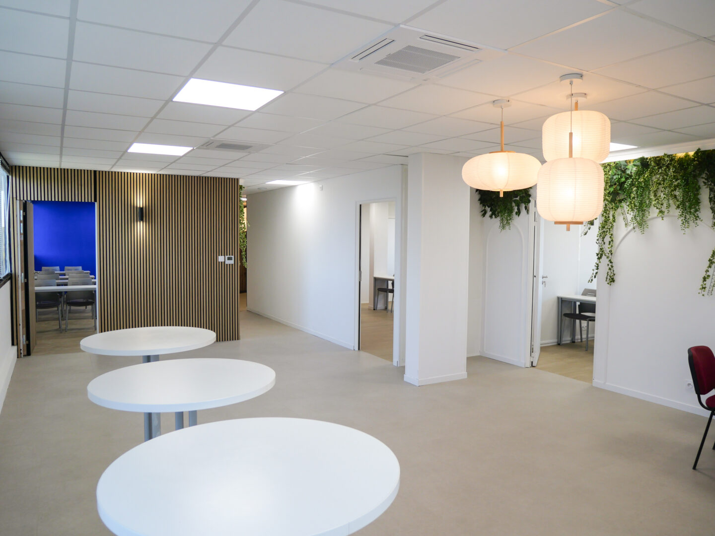 Espace commun dans un local professionnel à Toulouse avec des luminaires suspendus, aménagé par un architecte d'intérieur.