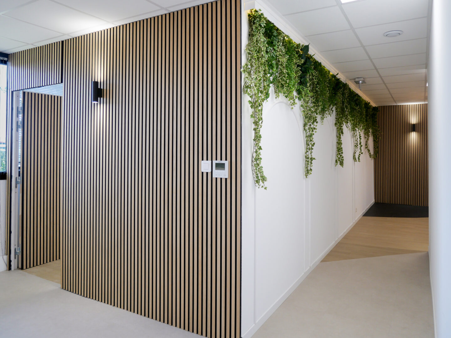 Couloir moderne avec un mur végétal dans des bureaux à Toulouse, optimisé par un spécialiste du design intérieur.