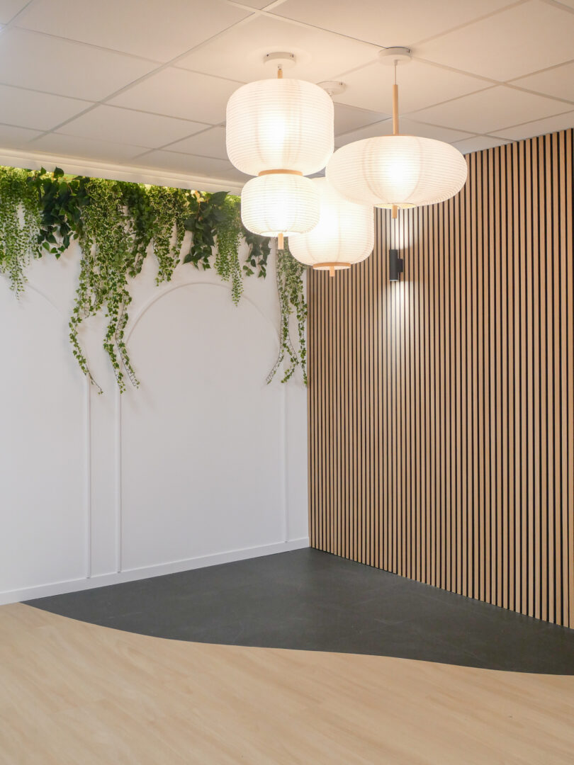 Espace moderne optimisé par un designer d'intérieur à Toulouse, avec des luminaires suspendus et des panneaux en bois.