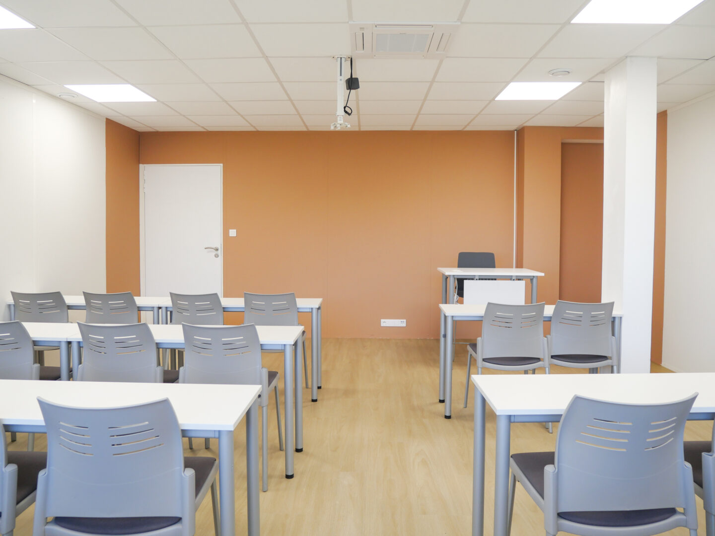 Salle de formation avec des murs ocre dans des bureaux à Toulouse, modernisée par un rénovateur d'intérieur.