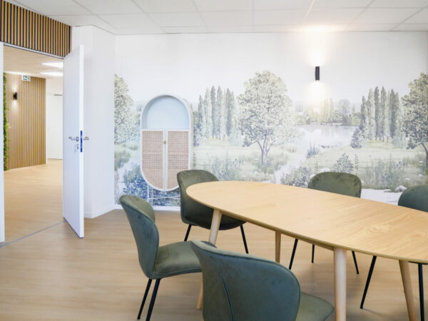 Salle de réunion dans des bureaux professionnels rénovés à Toulouse, décorée d'une fresque murale représentant un paysage naturel avec des arbres et un lac.