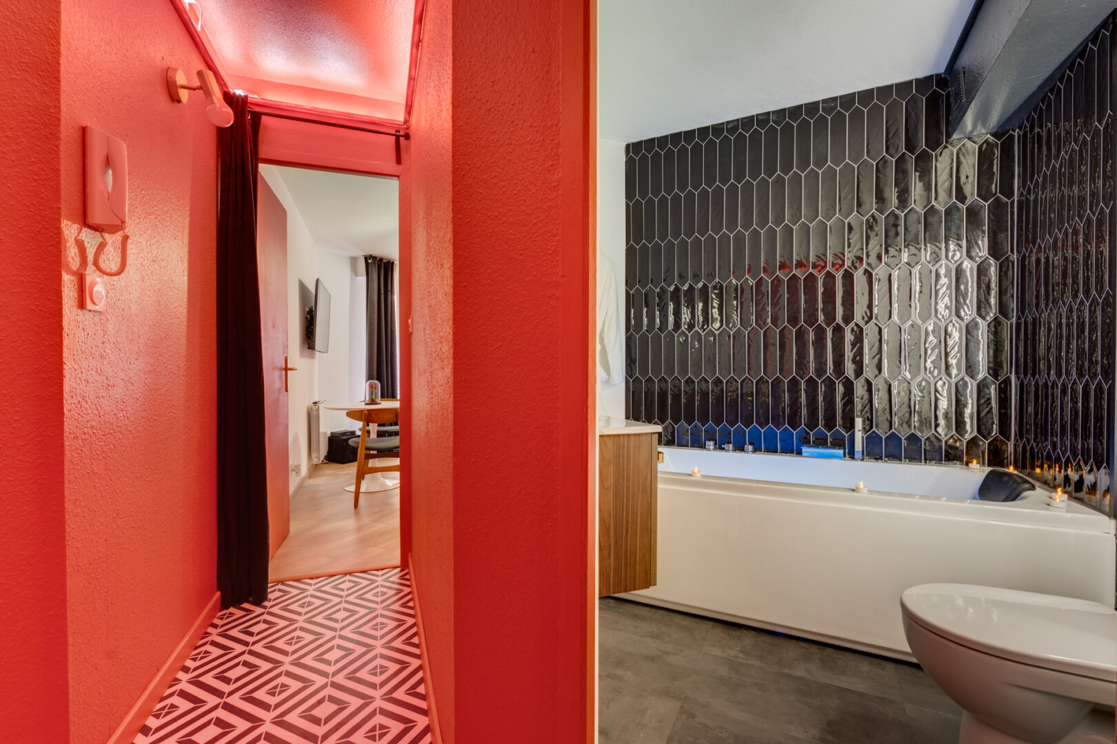 entrée rouge en contraste avec salle de bain noir